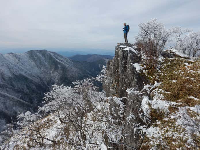 雪山の崖に立つ人