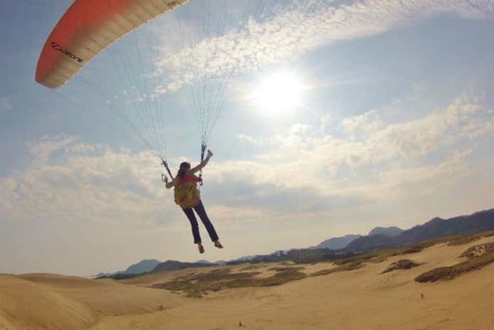 鳥取砂丘パラグライダー体験スクールで飛ぶ人