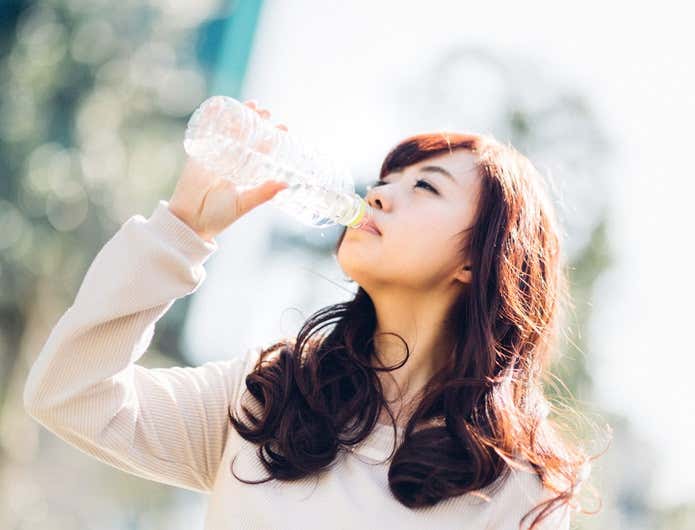 脱水症状で飲み物を飲む女性