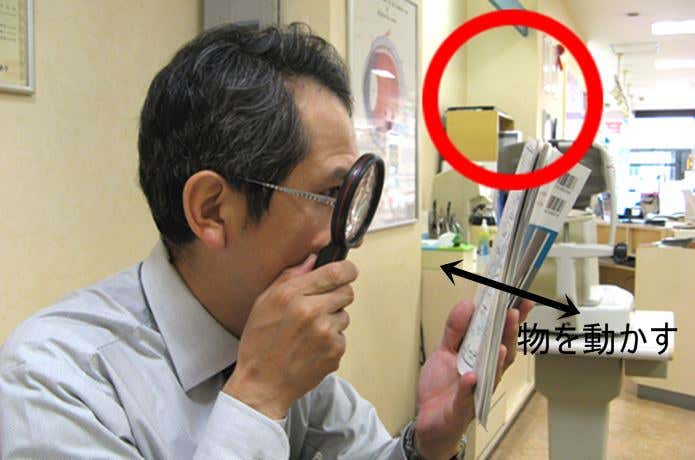 正しいルーペの使い方をする男性
