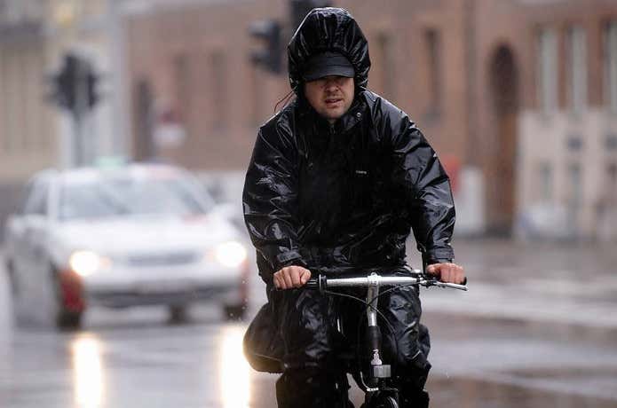 レインジャケットを着て自転車に乗る男性