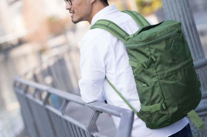 コールマンのバッグを背負った男性