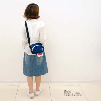 チャムスの青いショルダーバッグを持った女性