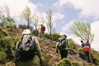 モンベルのバックパックを背負って山を登る人