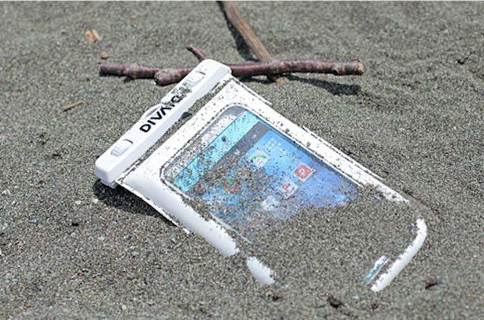 防水スマホケースを砂に埋める