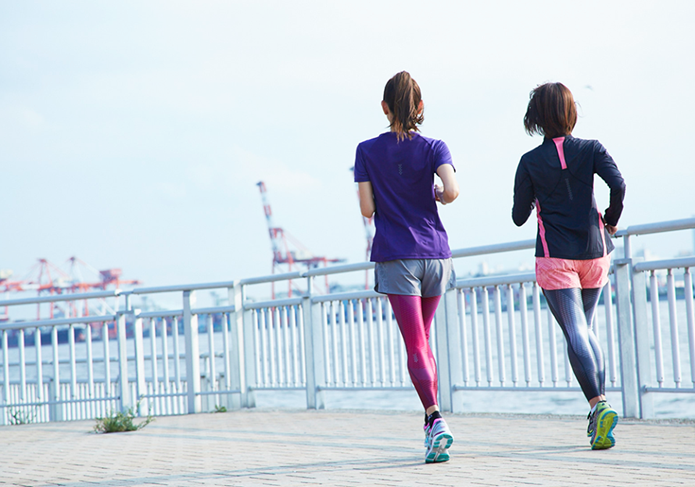 アシックスのランニングシューズを履いて走る女性