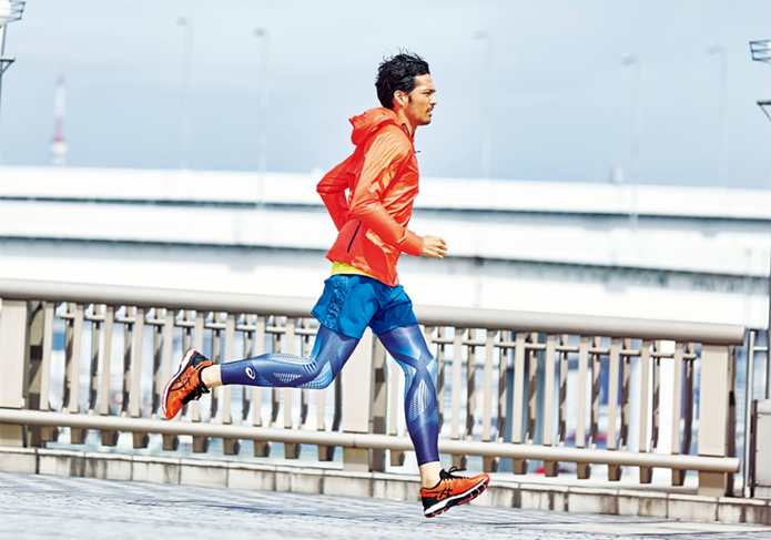 アシックスのランニングシューズを履いて走る男性