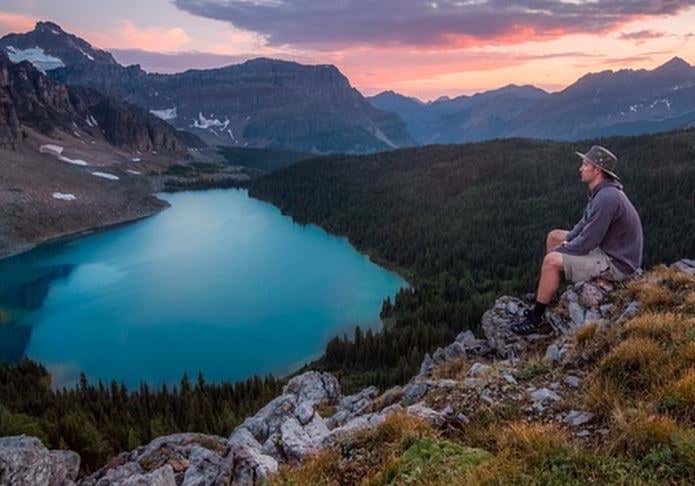 山から湖を眺める男性
