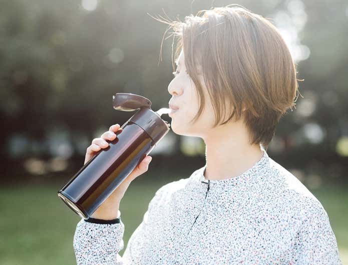 ストロー付きの水筒で水分を摂る女性