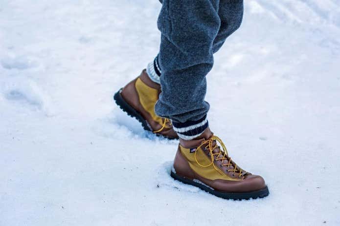 雪の中を歩く男性の足