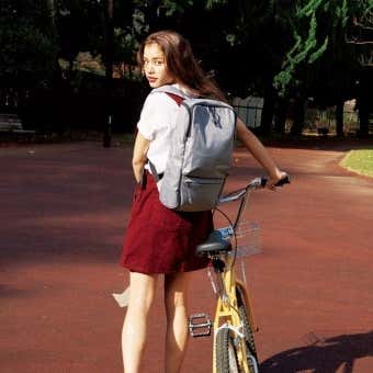 リュック背負って自転車に乗る女性