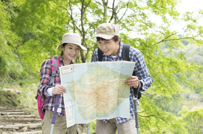 登山で地図読みをする男女