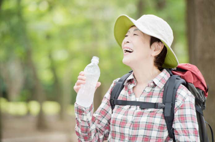 登山中に飲み物を飲む女性