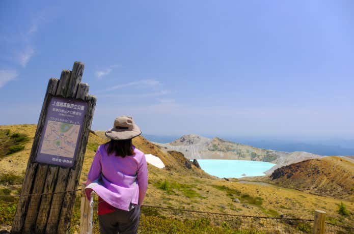 湯釜を見つめる登山者