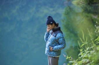 ノースフェイスとミナペルホネンのコラボダウンを着た女性