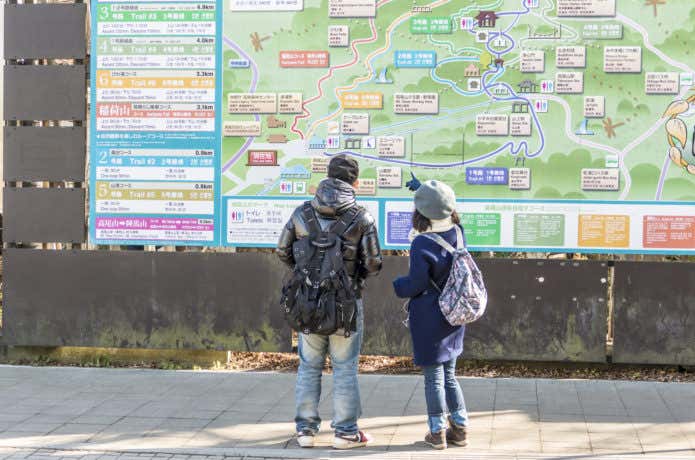 高尾山口駅前でリュックを背負っている登山客