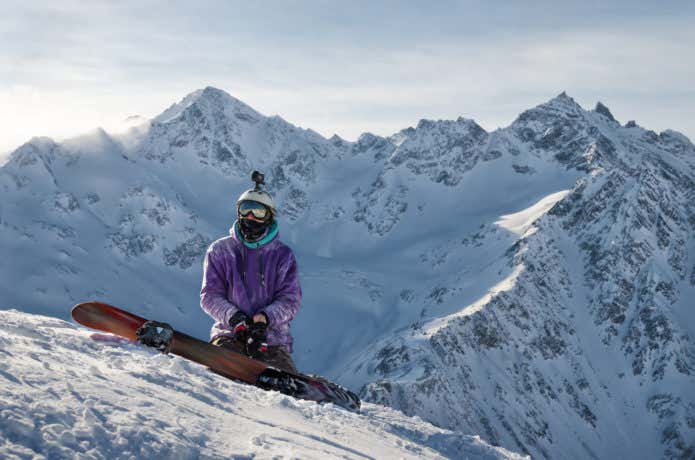 雪山でスノボをする男性