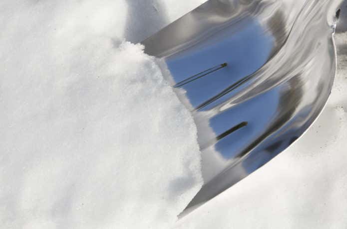 スノーショベルで雪を掘る