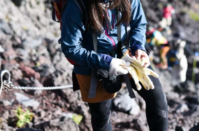 軍手をして登山する女性
