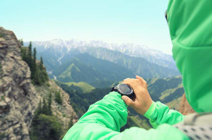 GPS時計を見る登山者
