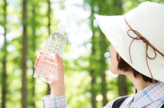 登山中水を飲む女性