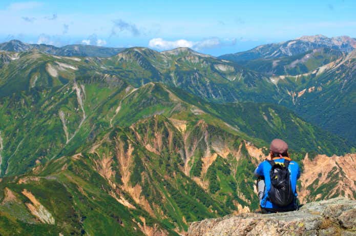 北アルプスを眺める登山者