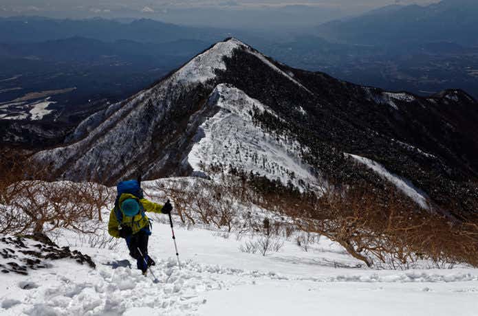 雪の八ヶ岳連峰・権現岳稜線を登る登山者