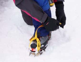 アイゼンを装着する登山者