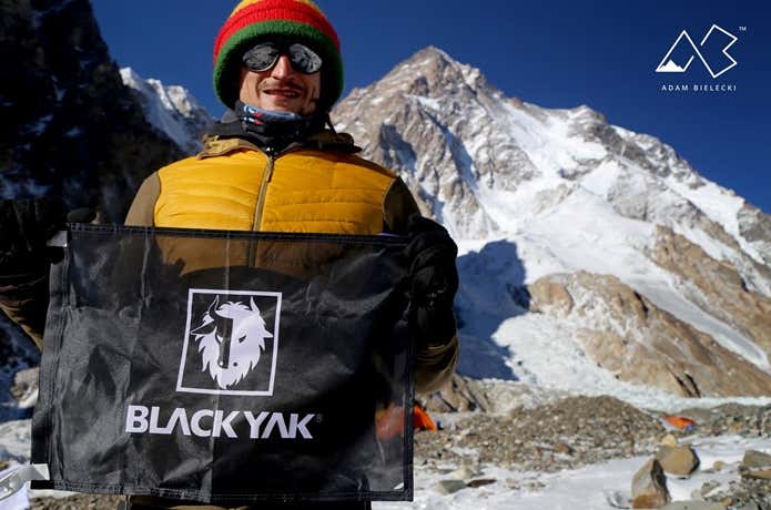 BLACK YAKのロゴが描かれた旗を持つ登山者
