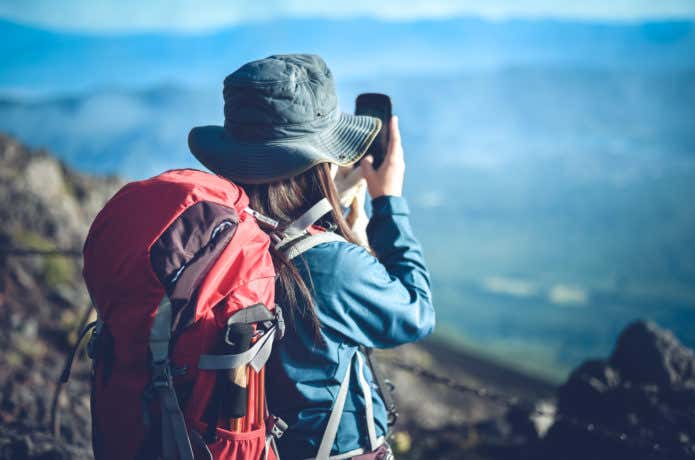 登山中にスマホを使う女性