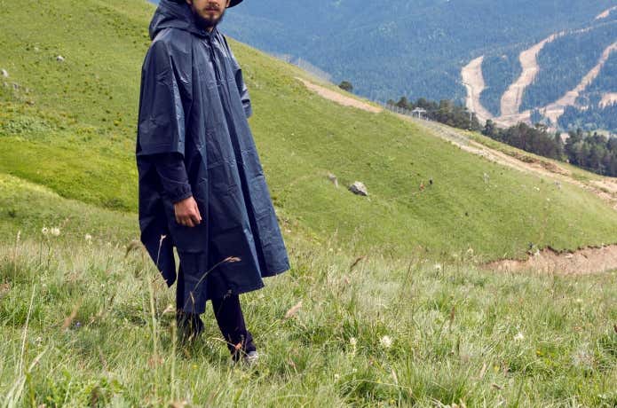 山でポンチョを着ている男性