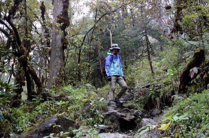 レインウェアを着て登山する男性