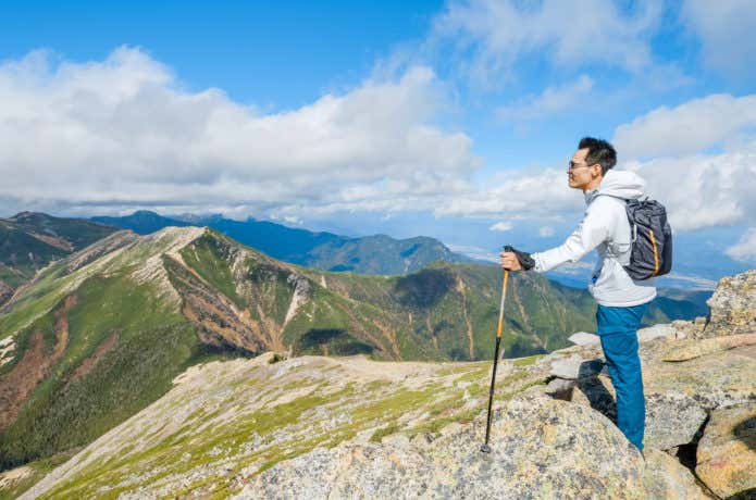 常念岳山頂に立つ登山者