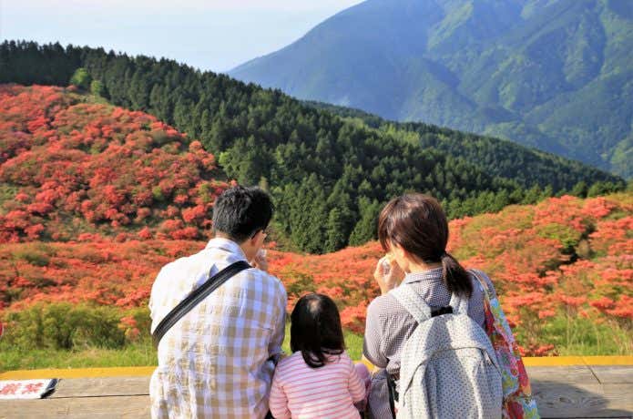 山でおにぎりを食べる家族
