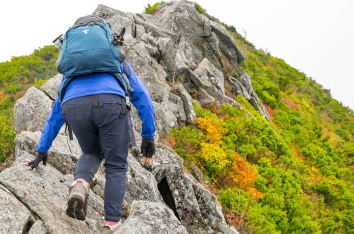 岩場を登山する女性