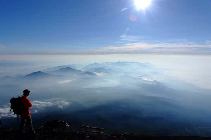 山頂からの景色を見る登山者