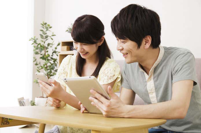 スマホやタブレットを見る男女