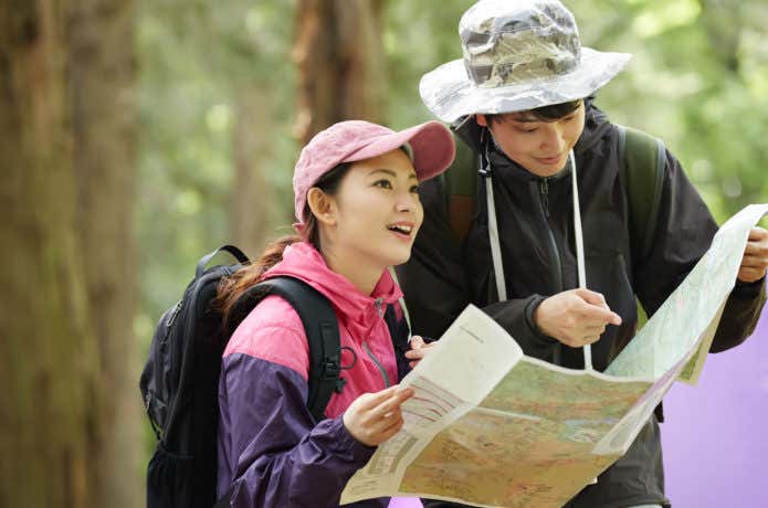 山歩きで地図を見るカップル