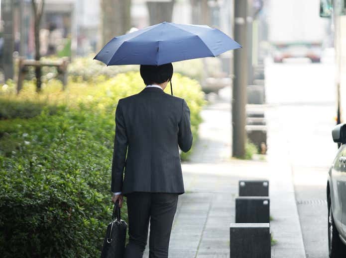 傘をさすビジネスマン