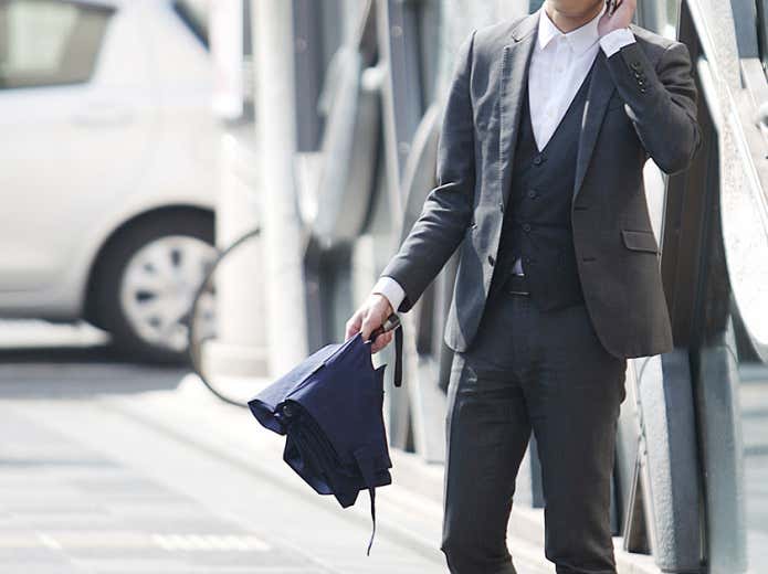 折りたたみ傘を持つ男性