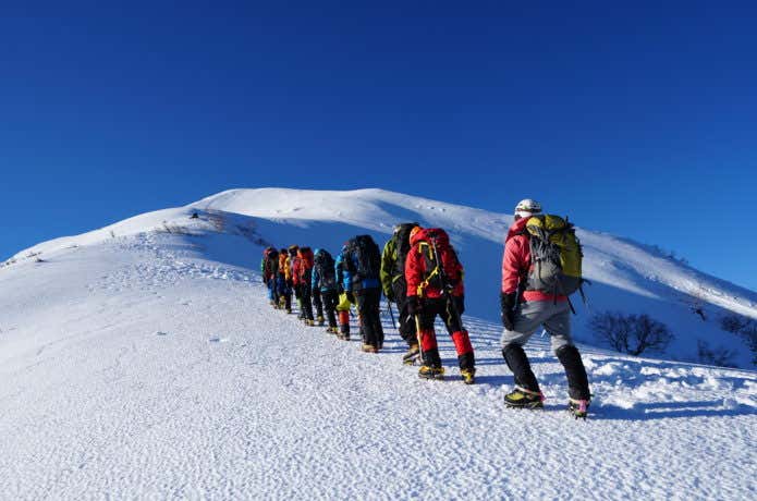 雪山を登る登山者グループ