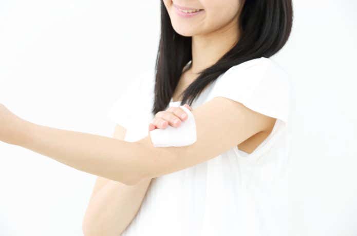 体を拭く女性