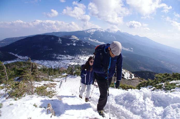 北横岳山頂をめざす石川ガイドと齋藤さん