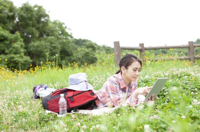 草原で休憩するオシャレな山ガール