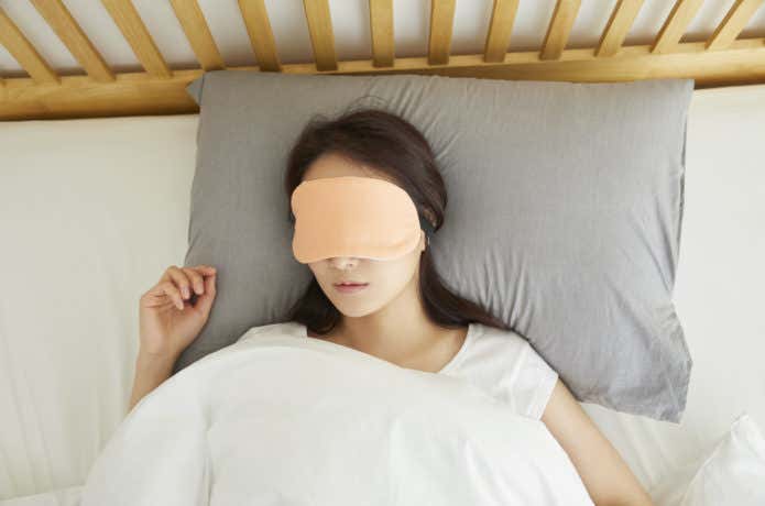 アイマスクを付けて寝る女性