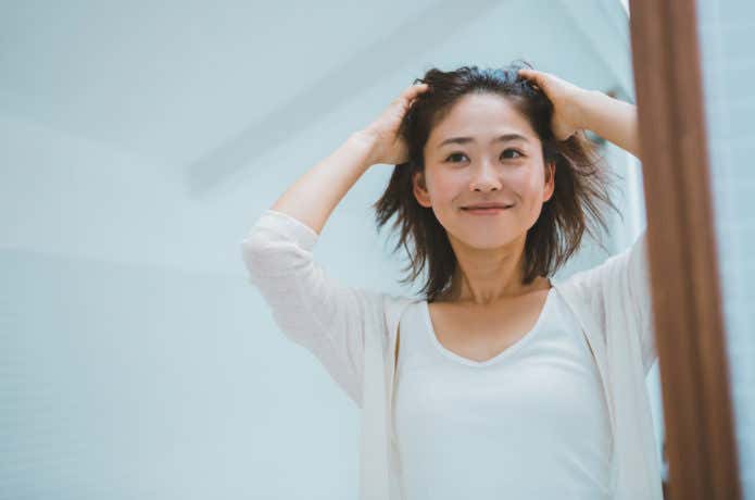 自宅でヘアケアをしている女性