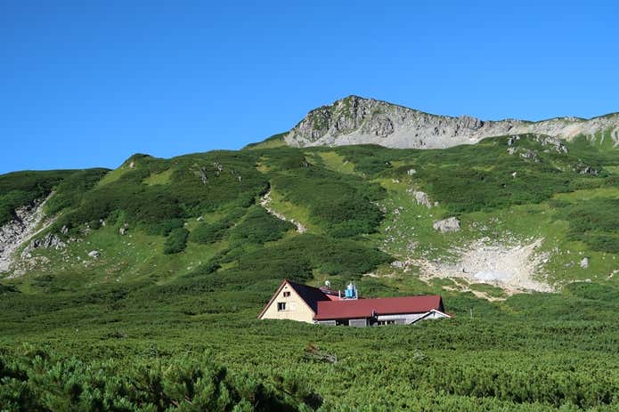 三俣蓮華岳を背景に立つ三俣山荘。