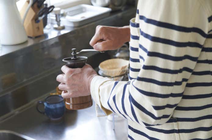 ミルでコーヒー豆挽く男性