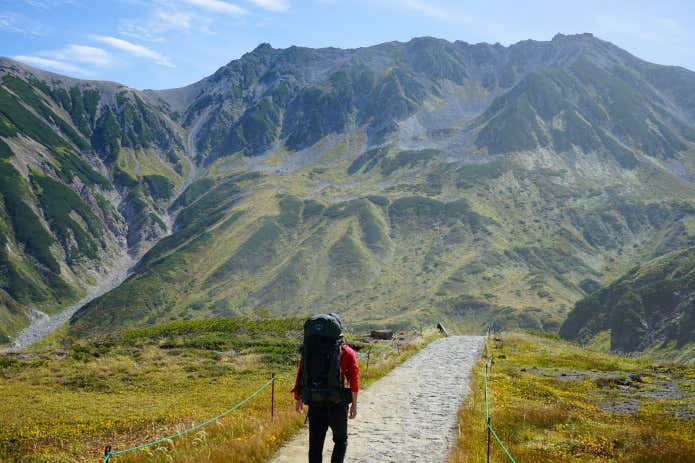 大型ザックを背負って歩く登山者