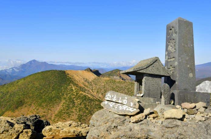 安達太良山山頂の祠と磐梯山を望む